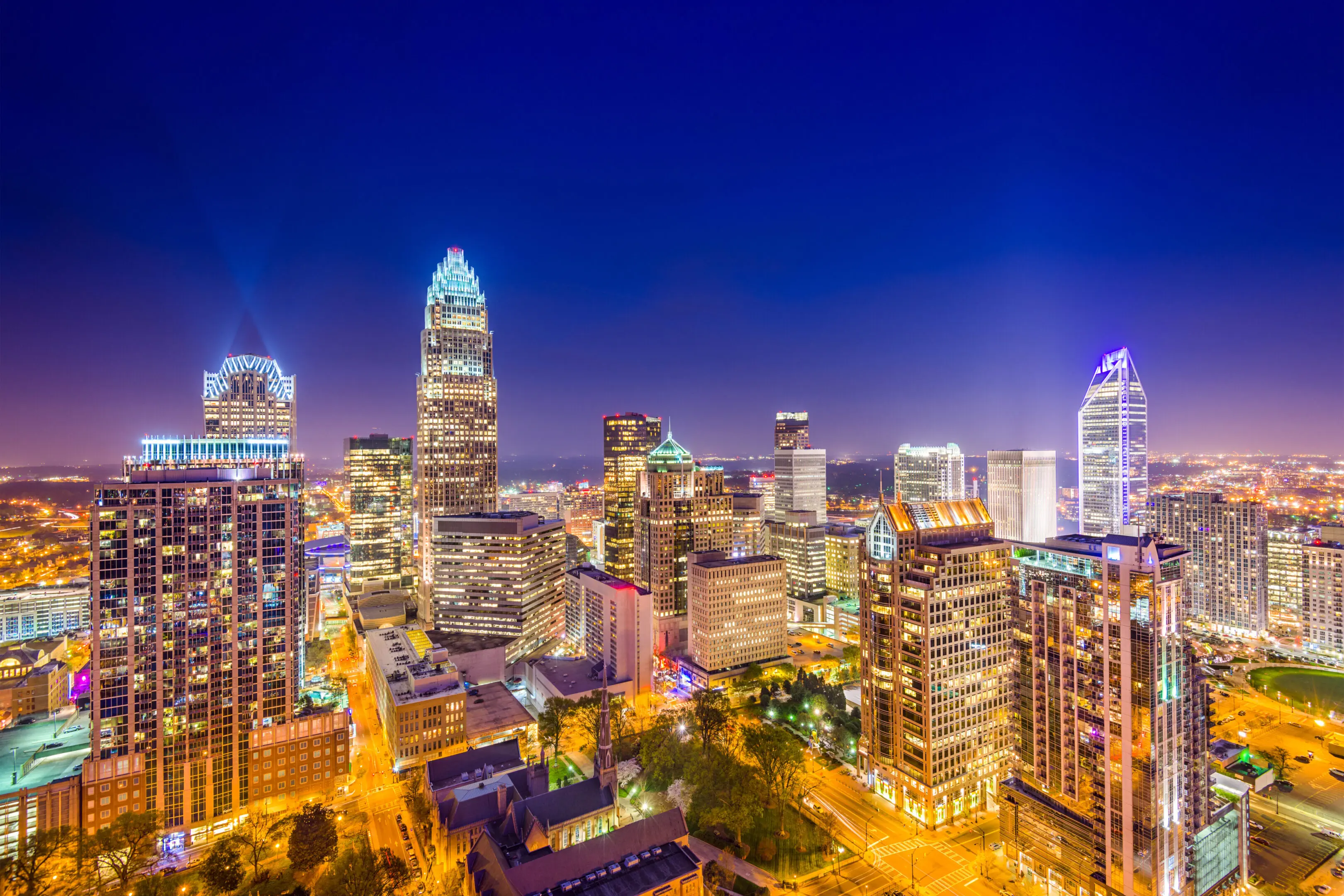 A city skyline with many buildings lit up at night.